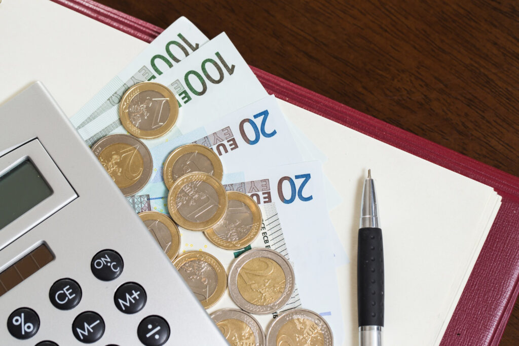 Niemieckie Euro, banknoty, kalkulator, notatnik i długopis leżą na stole